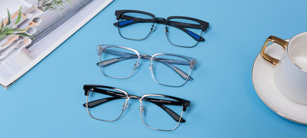 three pairs of browline glasses on a blue table