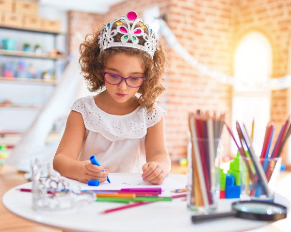 young girl wearing a crown and coloring