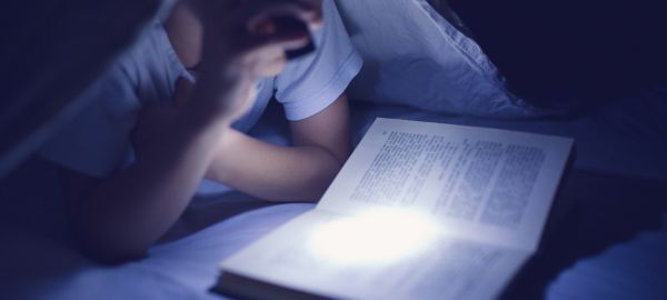 Flashlight lighting a book