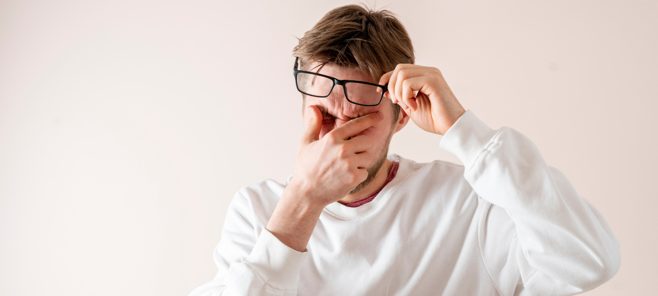 man wearing eyeglasses having an headache