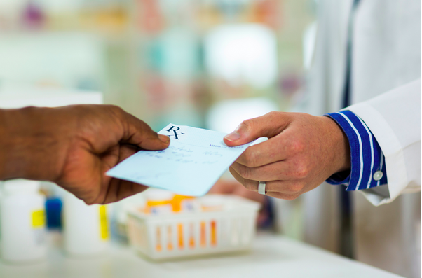 doctor handing a prescription copy to a patient