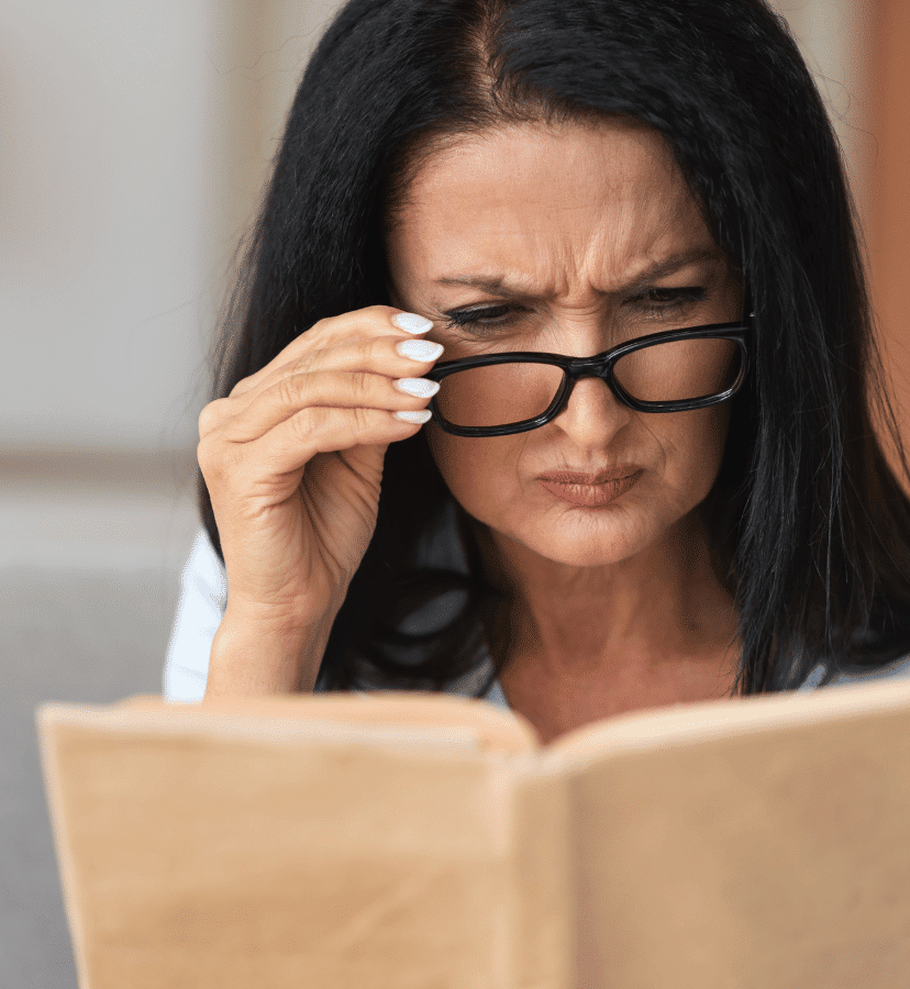 woman with glasses adjusting glasses to read