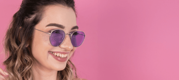 woman wearing purple tinted lenses on pink background