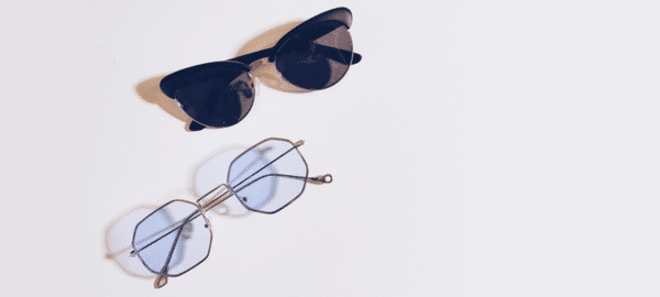 eyeglasses and sunglasses on a grey flat surface
