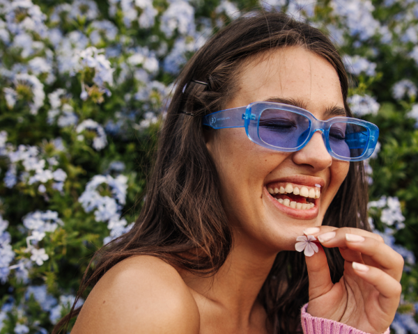 woman wearing blue sunglasses smiling