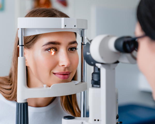 optician performing eye exam on female patient